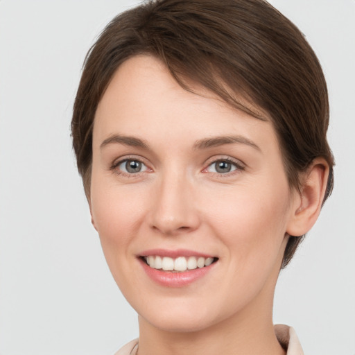 Joyful white young-adult female with short  brown hair and grey eyes