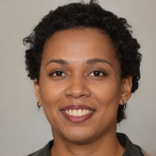 Joyful black young-adult female with short  brown hair and brown eyes