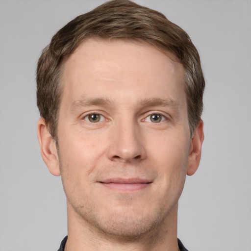 Joyful white adult male with short  brown hair and grey eyes