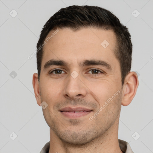 Joyful white young-adult male with short  black hair and brown eyes