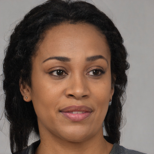 Joyful black young-adult female with medium  black hair and brown eyes