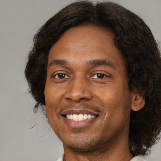 Joyful black adult male with medium  brown hair and brown eyes