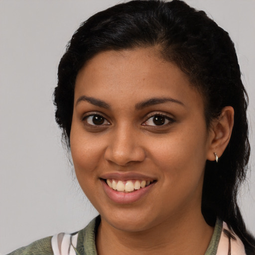 Joyful latino young-adult female with medium  brown hair and brown eyes