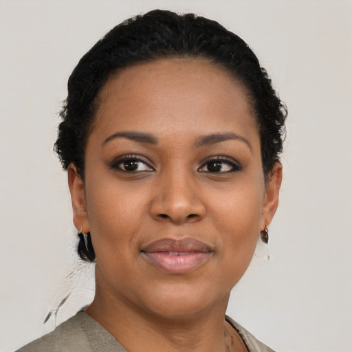 Joyful black young-adult female with short  black hair and brown eyes