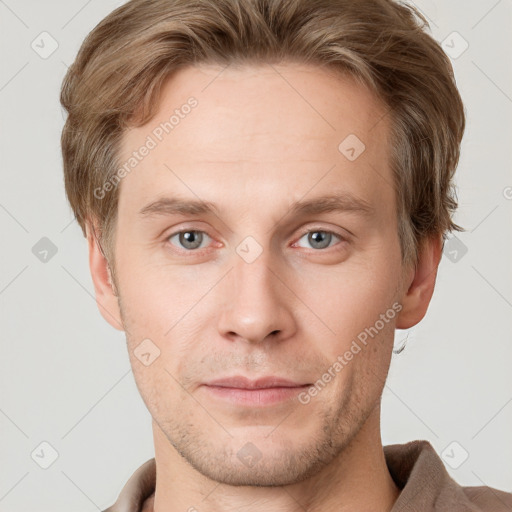 Joyful white young-adult male with short  brown hair and grey eyes