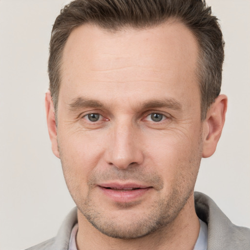 Joyful white adult male with short  brown hair and brown eyes