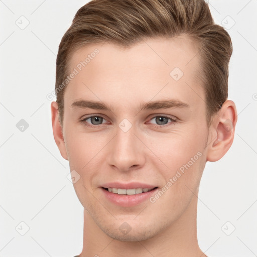 Joyful white young-adult male with short  brown hair and grey eyes