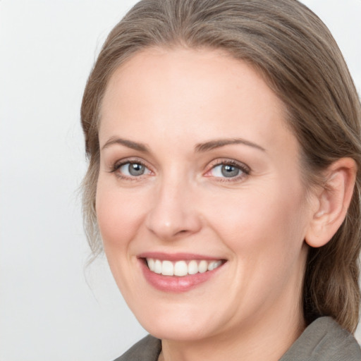 Joyful white young-adult female with medium  brown hair and grey eyes