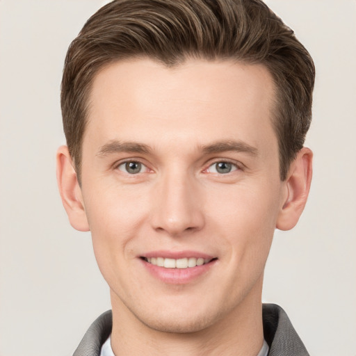 Joyful white young-adult male with short  brown hair and grey eyes