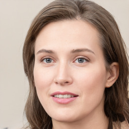 Joyful white young-adult female with long  brown hair and blue eyes