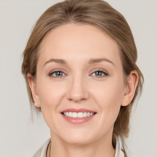 Joyful white young-adult female with medium  brown hair and blue eyes