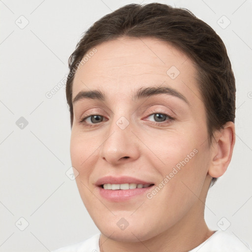 Joyful white young-adult female with short  brown hair and brown eyes