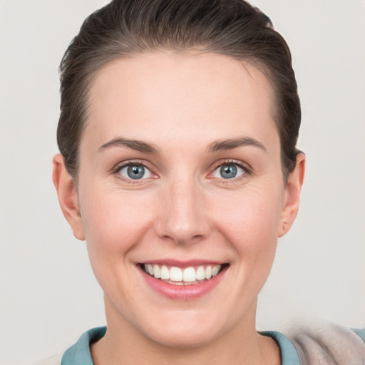 Joyful white young-adult female with short  brown hair and grey eyes