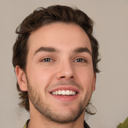 Joyful white young-adult male with short  brown hair and green eyes