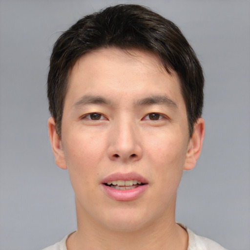 Joyful asian young-adult male with short  brown hair and brown eyes
