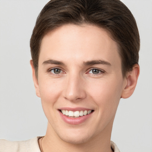 Joyful white young-adult female with short  brown hair and grey eyes