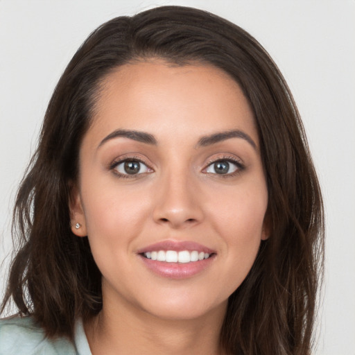 Joyful white young-adult female with long  brown hair and brown eyes