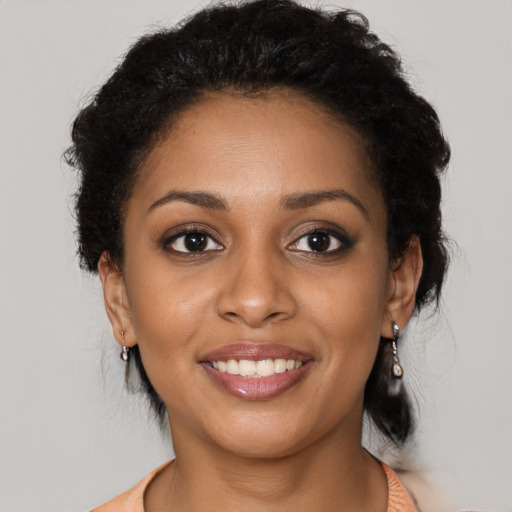 Joyful black young-adult female with medium  brown hair and brown eyes