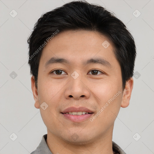 Joyful asian young-adult male with short  brown hair and brown eyes