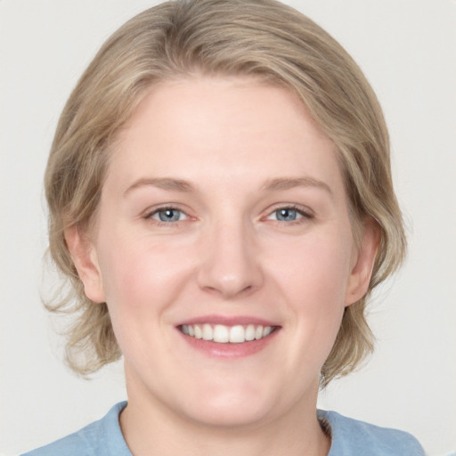 Joyful white young-adult female with medium  brown hair and blue eyes