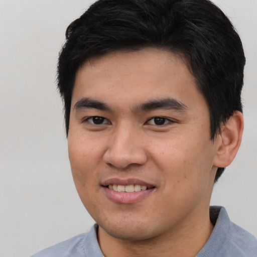 Joyful asian young-adult male with short  brown hair and brown eyes