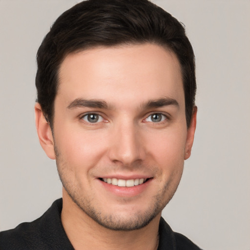 Joyful white young-adult male with short  brown hair and grey eyes