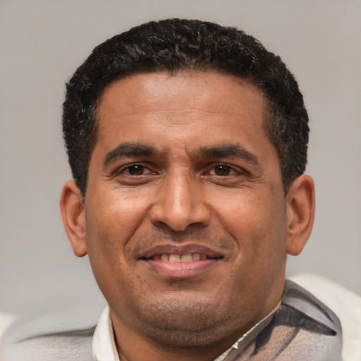 Joyful latino adult male with short  black hair and brown eyes
