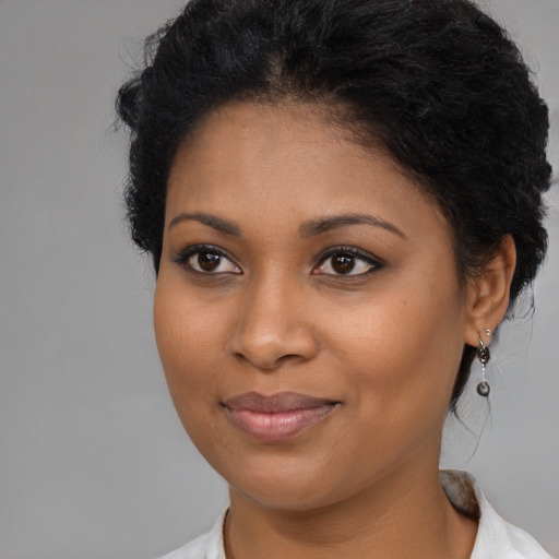 Joyful black young-adult female with medium  brown hair and brown eyes