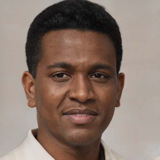 Joyful black young-adult male with short  brown hair and brown eyes