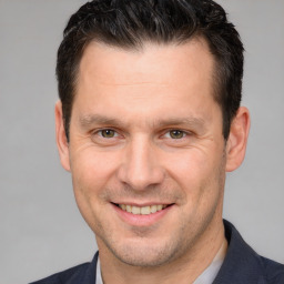 Joyful white adult male with short  brown hair and brown eyes