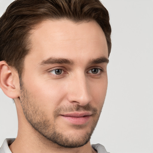 Joyful white young-adult male with short  brown hair and grey eyes