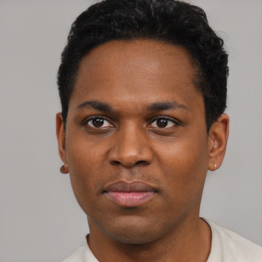 Joyful black young-adult male with short  black hair and brown eyes