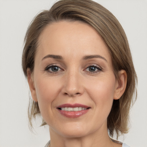 Joyful white adult female with medium  brown hair and brown eyes