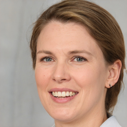 Joyful white adult female with medium  brown hair and green eyes