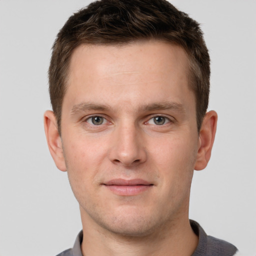 Joyful white young-adult male with short  brown hair and grey eyes