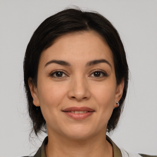 Joyful latino young-adult female with medium  brown hair and brown eyes