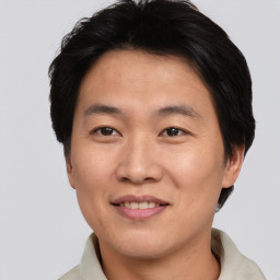 Joyful asian adult male with short  brown hair and brown eyes