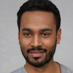 Joyful black young-adult male with short  black hair and brown eyes