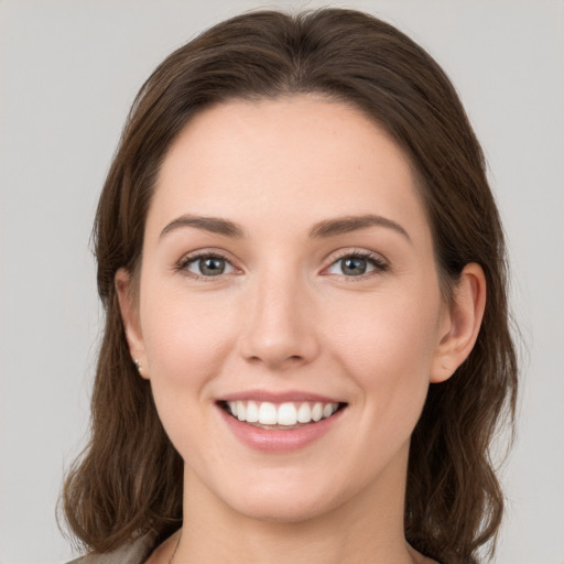 Joyful white young-adult female with medium  brown hair and green eyes