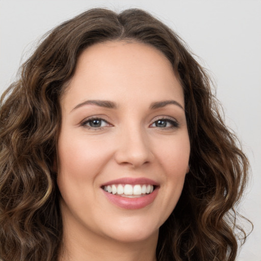 Joyful white young-adult female with long  brown hair and brown eyes