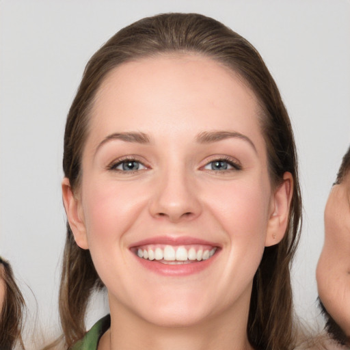 Joyful white young-adult female with long  brown hair and grey eyes