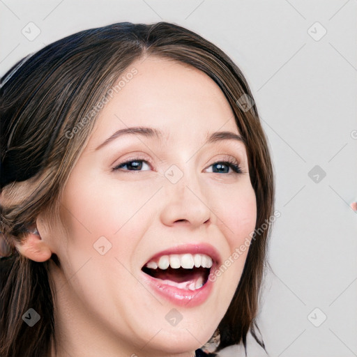 Joyful white young-adult female with long  brown hair and blue eyes