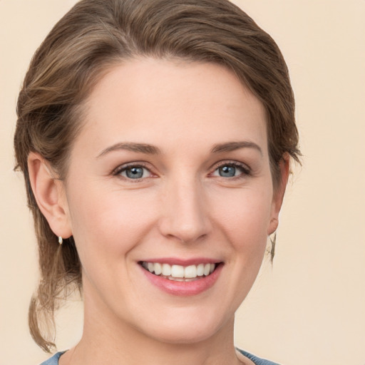 Joyful white young-adult female with medium  brown hair and grey eyes