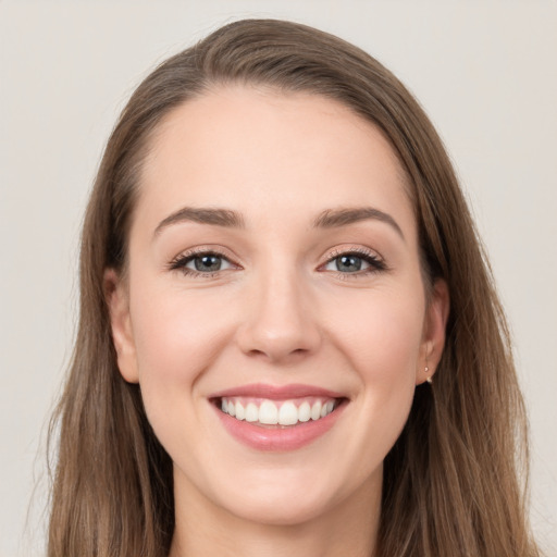 Joyful white young-adult female with long  brown hair and grey eyes