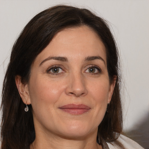 Joyful white adult female with long  brown hair and brown eyes