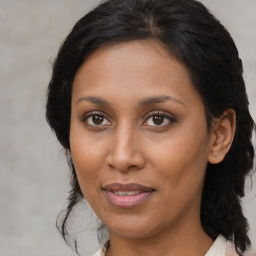 Joyful black adult female with medium  brown hair and brown eyes