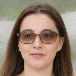 Joyful white adult female with long  brown hair and brown eyes