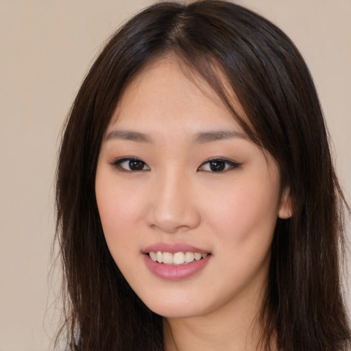 Joyful asian young-adult female with long  brown hair and brown eyes