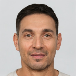 Joyful white adult male with short  black hair and brown eyes