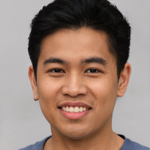 Joyful latino young-adult male with short  brown hair and brown eyes